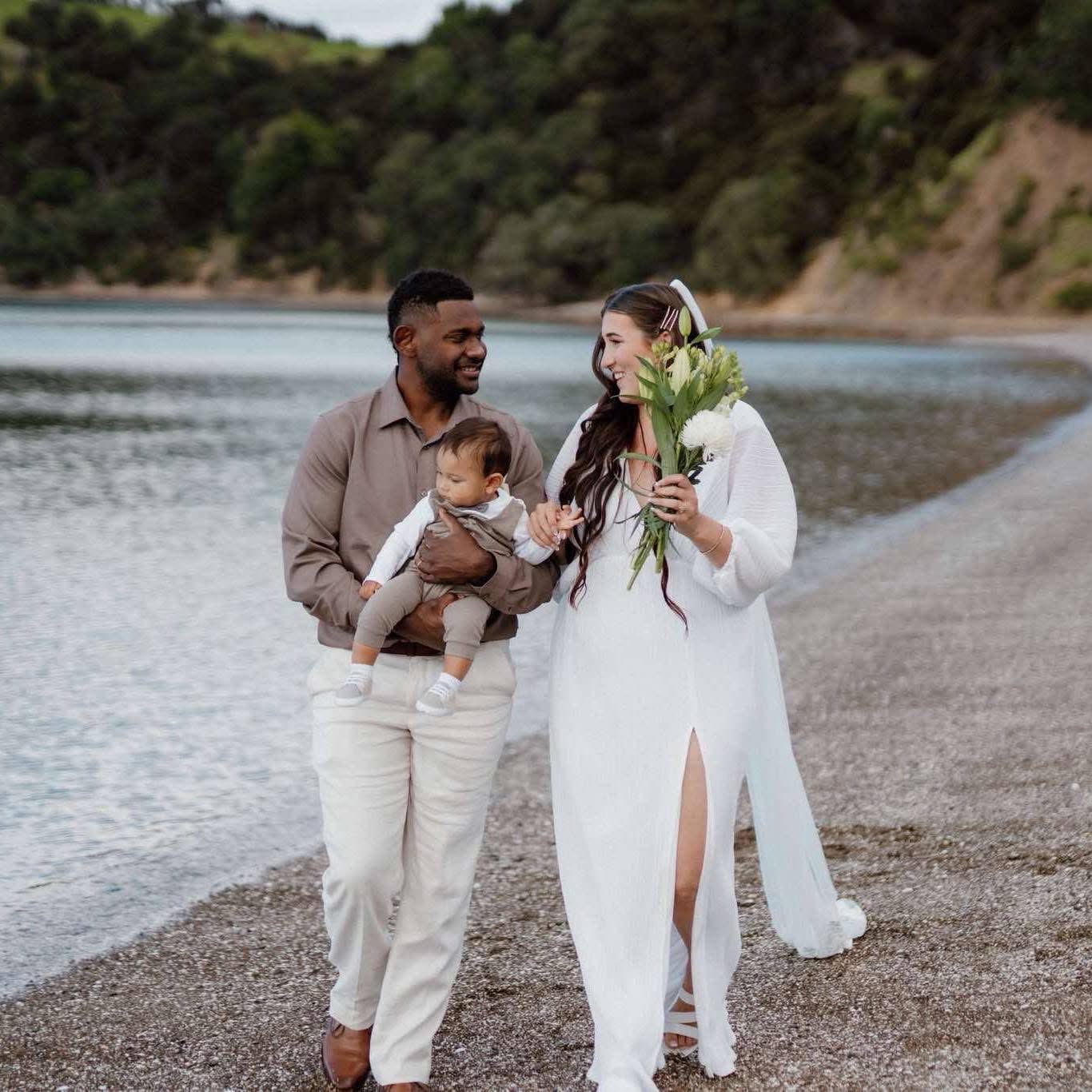 Chloe and Brandon walking hand in hand on the beach after their Waiheke Island wedding