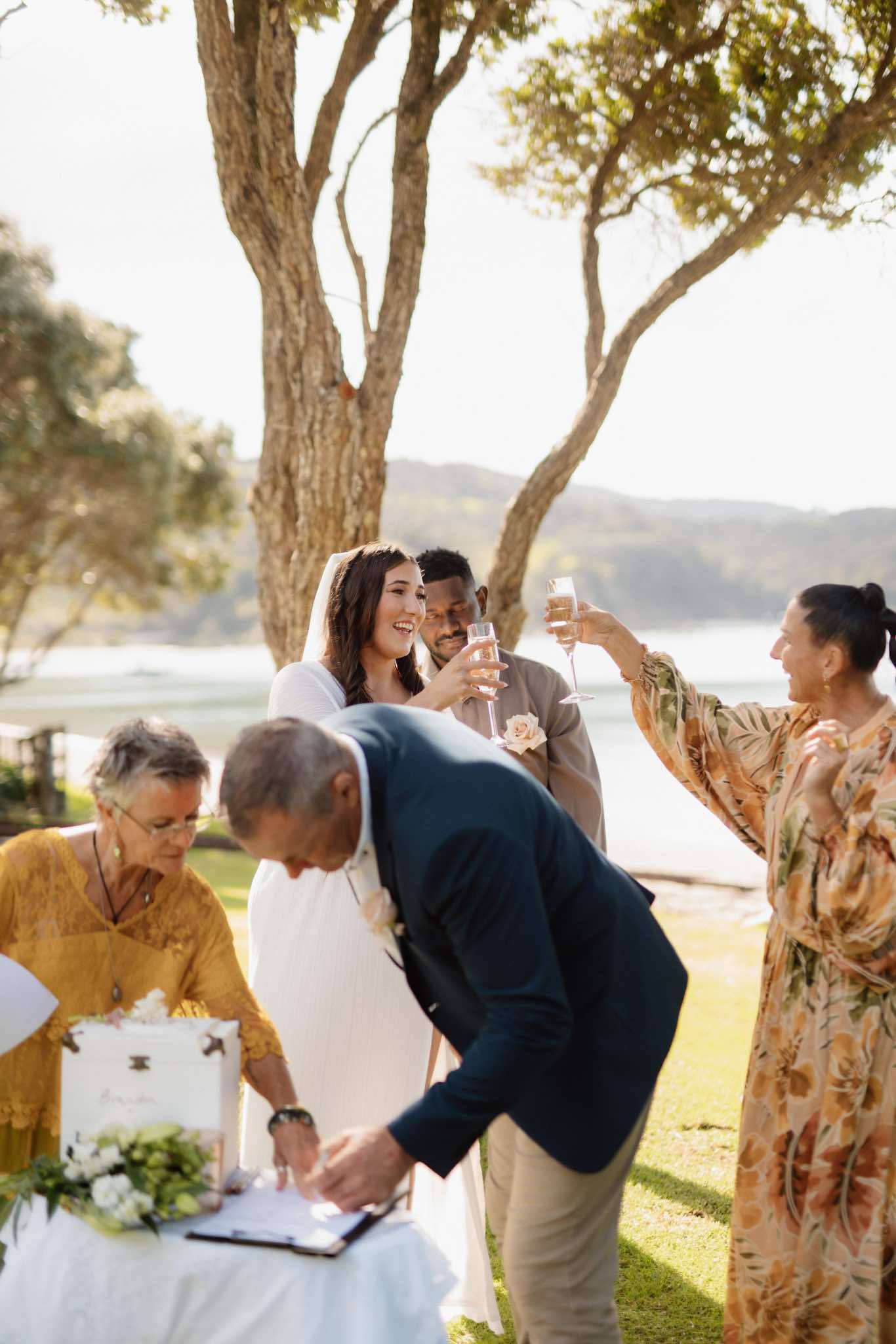 Chloe and Brandon celebrating with a champagne toast at their Waiheke Island wedding ceremony
