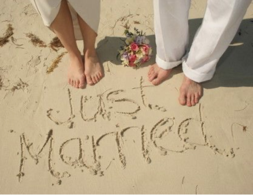 Just married - couple walking barefoot on the beach at Waiheke Island