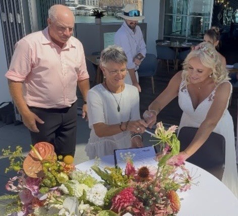 Sue and Pablo signing the marriage register with Linda at their Waiheke Island wedding