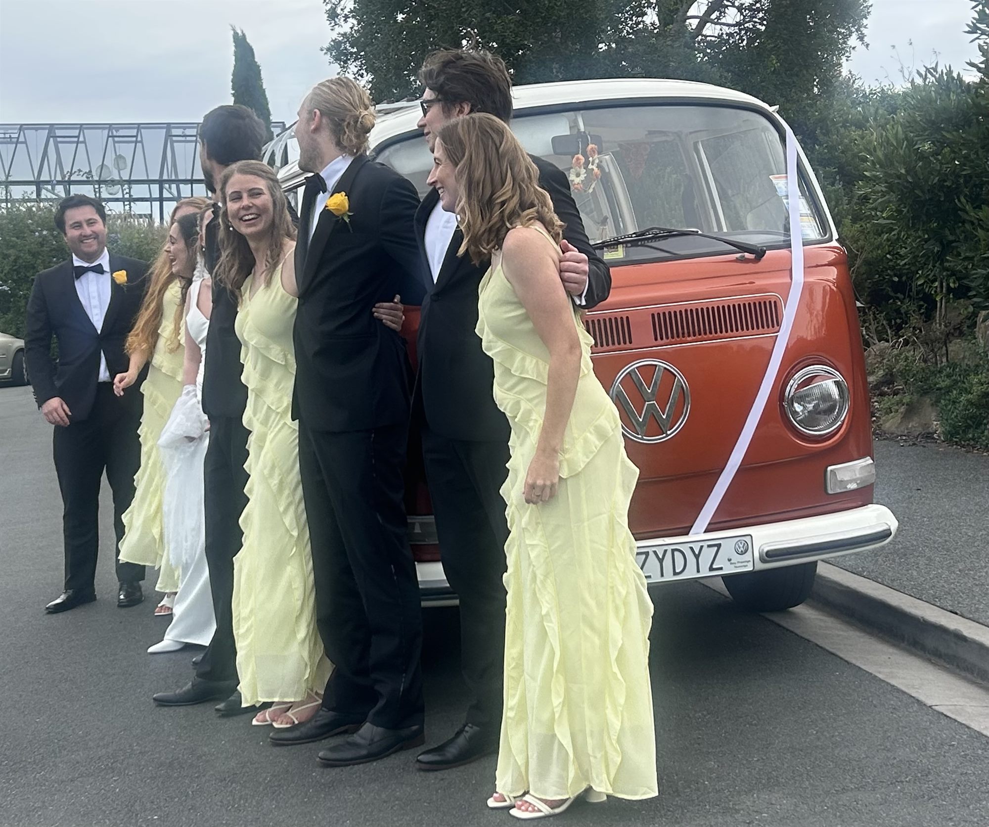 Wedding party gathering around Solana the 1969 Kombi van on Waiheke Island